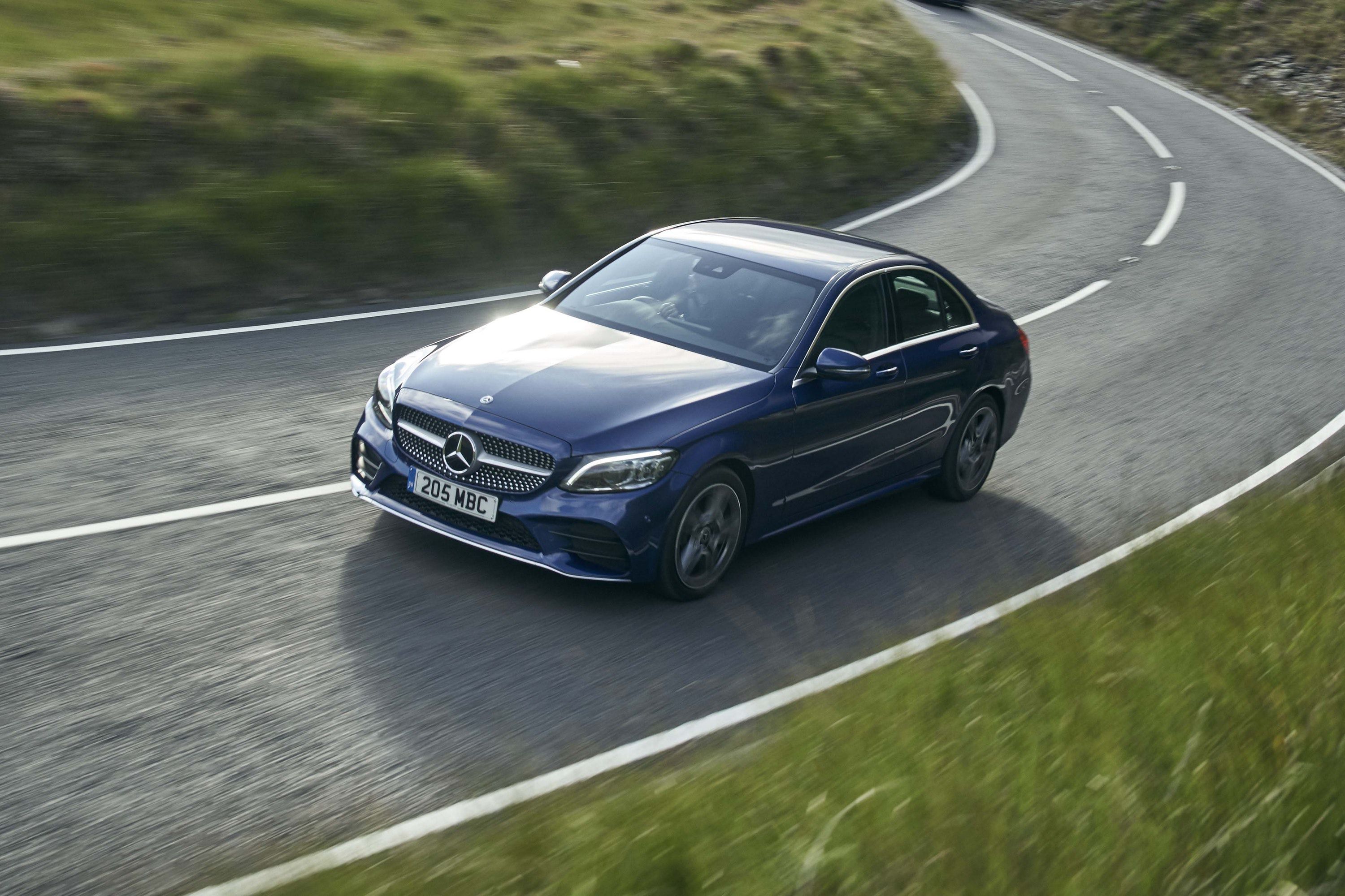 Blue Mercedes-Benz C-Class driving on a road
